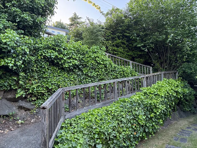 Private path from street level winds down to the house. Stairs on the other side are shared with neighbor.