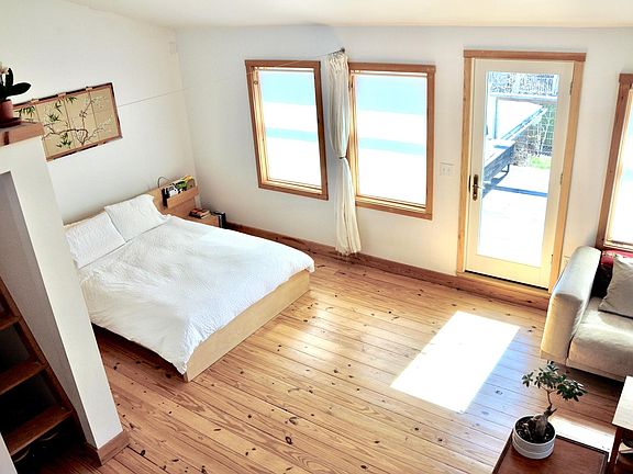 Spacious master bedroom with high ceilings and rooftop deck