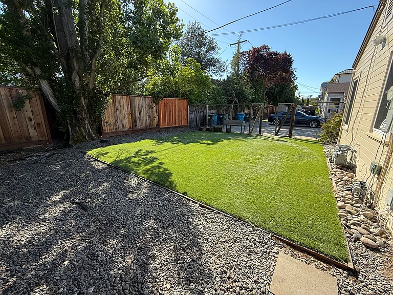 Private rear yard with artificial turf.
