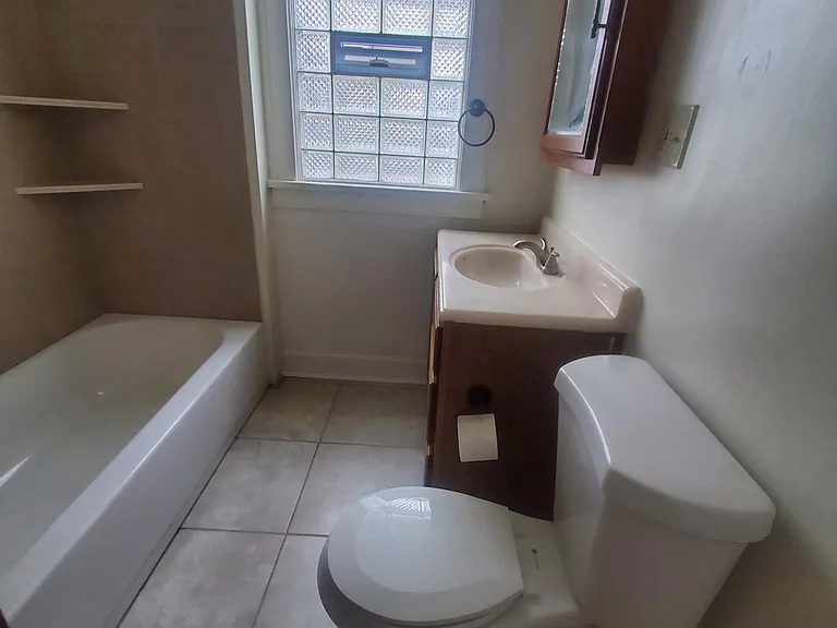 Ceramic tile on floor and shower with vent in window