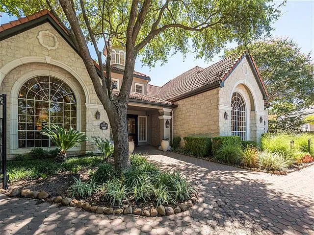 Leasing office entrance under shade trees surrounded by green landscape
