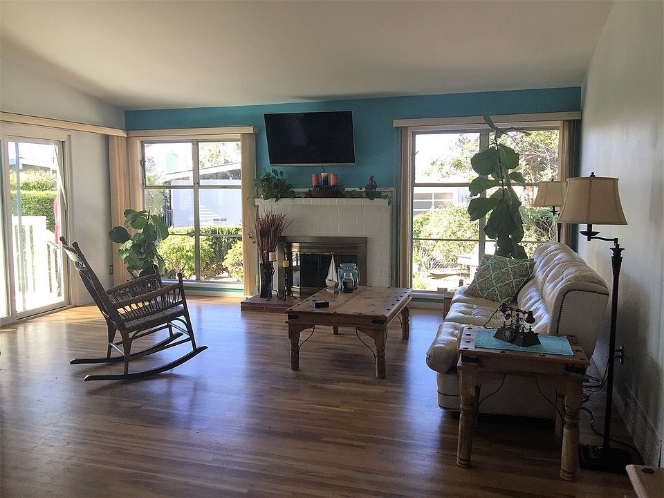 Hardwood flooring, fireplace, large windows on either side of brick fireplace with hearth & mantle.  Sliding door with raised de