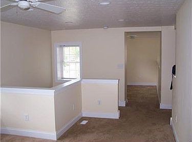 Alternate view of living room showing the hallway to the main entrance.