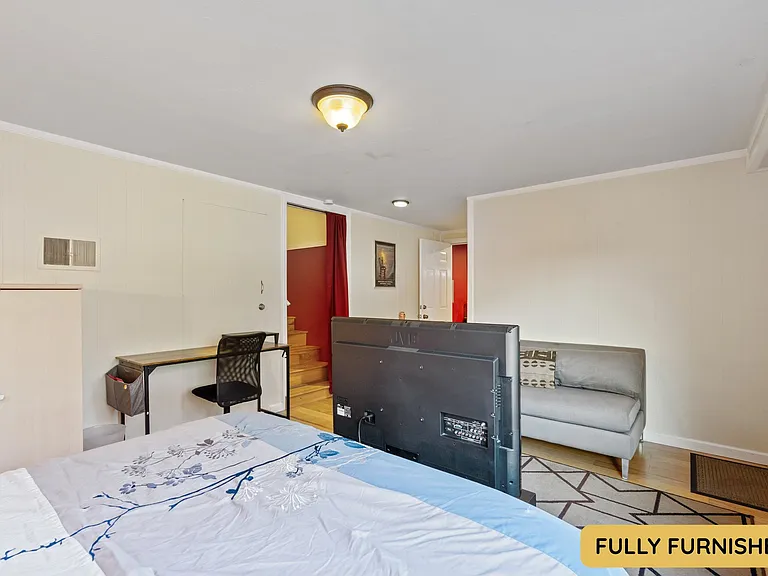 Downstairs is a large bedroom with ensuite full bathroom, queen bed, smart TV, sitting area, wall table, desk & chair, dresser, XL closet, large windows and an exterior door onto the backyard. Also connects to the laundry and bonus space.