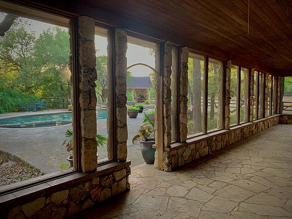 Outdoor living space with stone tile and wood ceilings.