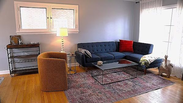 Large open-concept living area with refinished hardwood floors throughout and plenty of natural light