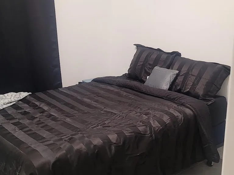 Private bedroom with a full-size bed, tile flooring, blackout curtains, and wall art for a comfortable retreat.
