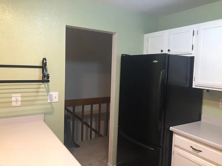 Kitchen with Black Appliances and built-in Cookbook Shelf.