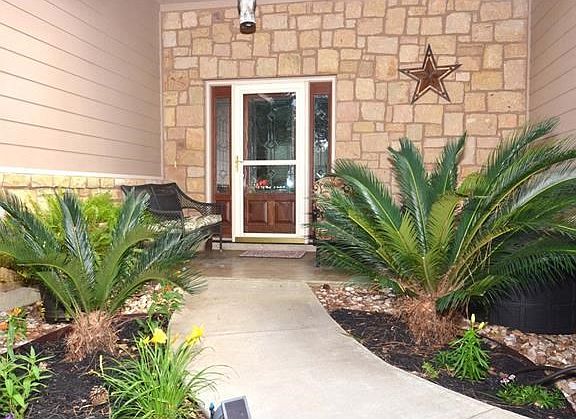 Entry has covered porch with ample space for patio furniture, gorgeous glass accents in the front door set the stage for the high end feeling this home offers