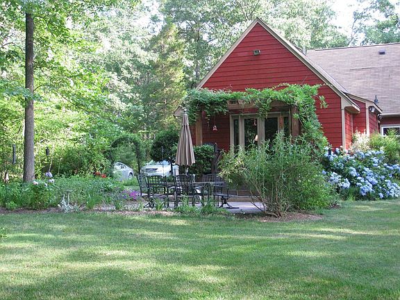back of house with wisteria covered arbor
