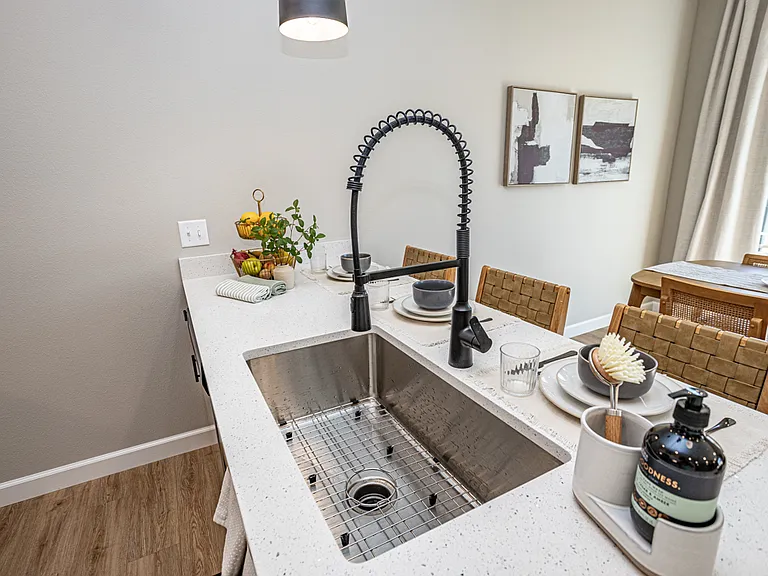 Kitchen with stainless steel appliances, breakfast bar, industrial sink and quartz countertops