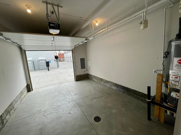 Attached oversized 1.5 car garage with smartphone garage door connectivity, EV charger, and storage space