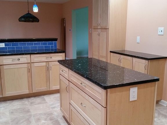 Kitchen, looking into dining room (with Tiffany-style pendant lamp) and pale green living room