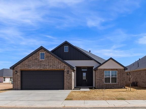 Single-story modern house with a brick and dark siding exterior, two-car garage, front porch, and a