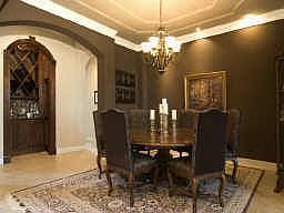 The formal dining room has art lighting, double crown molding, arched openings, 18x18 ceramic tile a