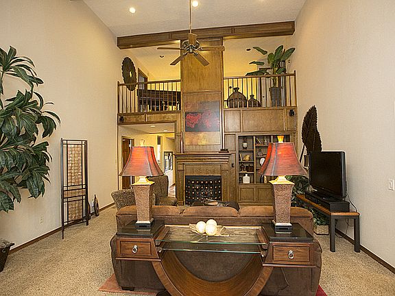 Soaring ceilings in the living room give a dramatic feel to this space.  A gas log fireplace is flanked by bookshelves.