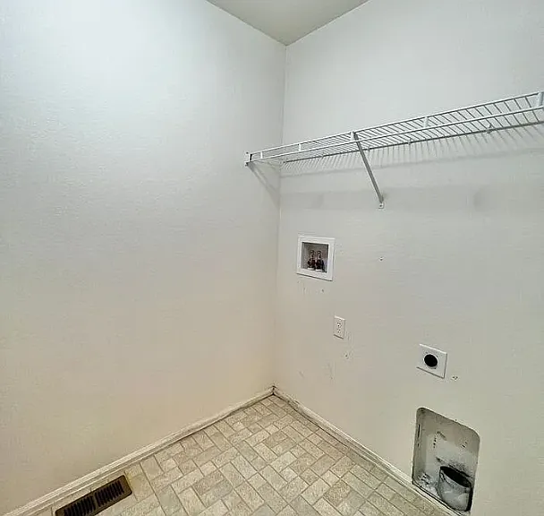 Laundry room with space for full-sized washer and dryer. Door to laundry room is across from the basement access door, just before the master bedroom door.