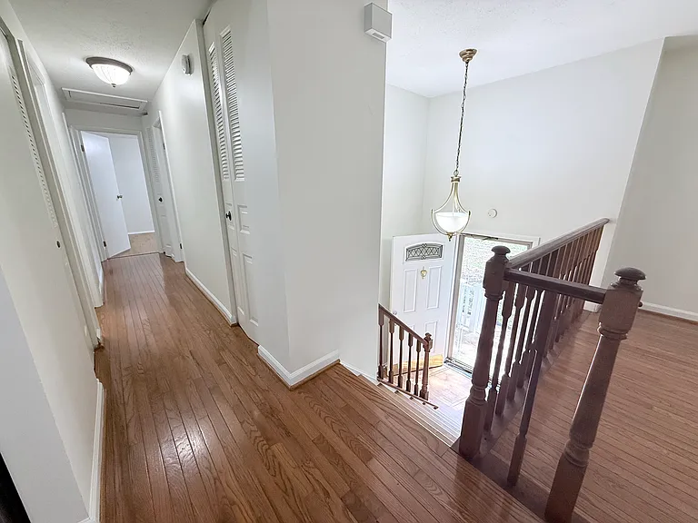 Top of staircase overlooking foyer and down the hallway where the bedrooms are located