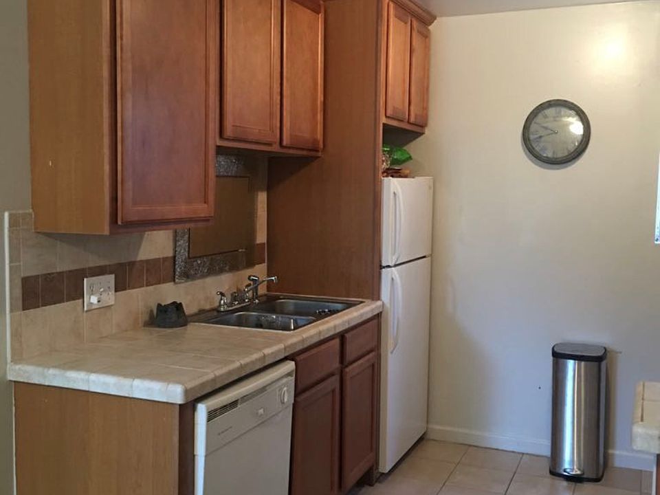 Kitchen with real wood cabinets, dishwasher, refrigerator, and gas stove.
