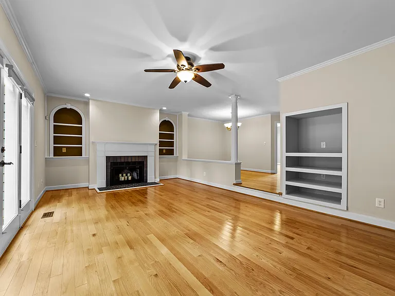 Spacious living room with fireplace, built-ins, hardwood floors, and open sightlines.