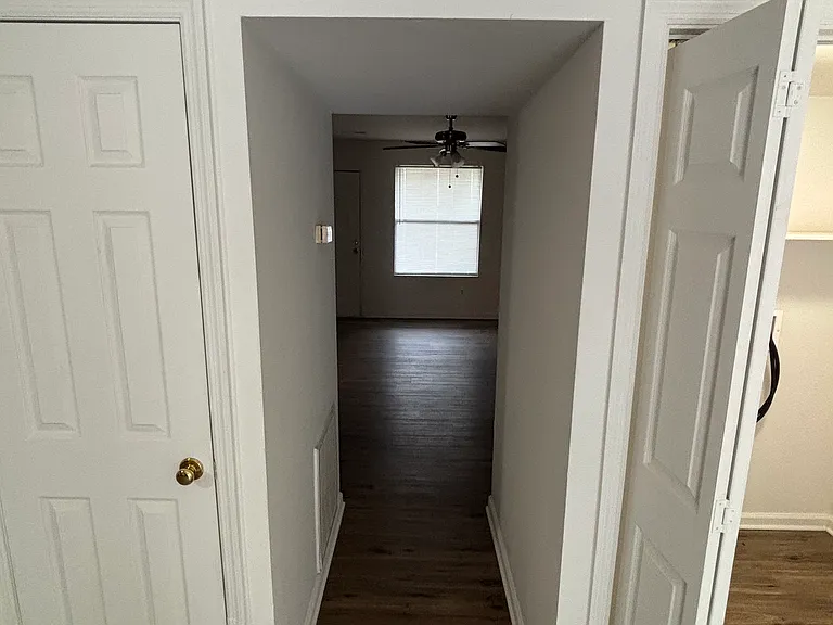 Hallway from the kitchen to the living room. To the right is your washer and dryer hook up.