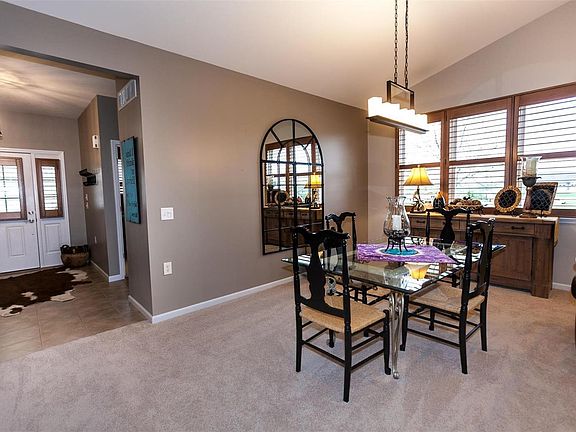 Dining/great room boasts vaulted ceiling with updated lighting and ceiling fan.