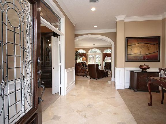 COME ON IN TO 15927 STORNOWAY AND VIEW TIMELESS ELEGANCE - Elegantly designed, the main foyer of the home features Travertine Tile with Decorative 8" tile inserts and white wood picture paneling. The Study is to the left with double doors and a stain