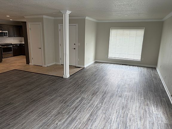 View of living room and front door. Kitchen to the left.
