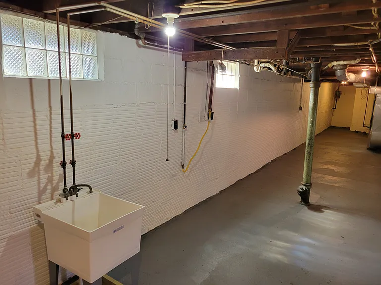 Basement, large, separate and private from other portions of the basement with gas and electric washer and dryer hook ups and block windows.