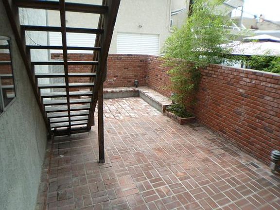 Private brick patio and stairway to single (3rd bedroom) exterior entry door