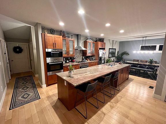 Kitchen/Dining Room with HUGE granite countertop and island. SS appliances, two convection ovens, microwave, dishwasher, fridge