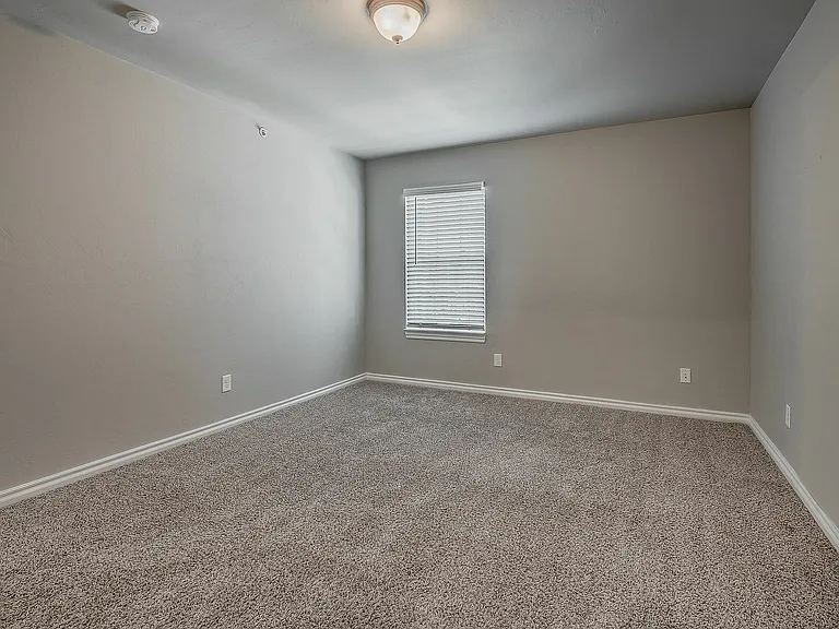 Transform this cozy space into your dream bedroom with natural light and plush carpeting.