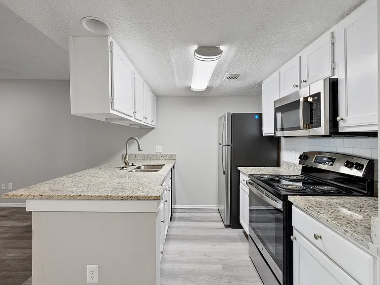 A kitchen with granite countertops and stainless steel appliances.