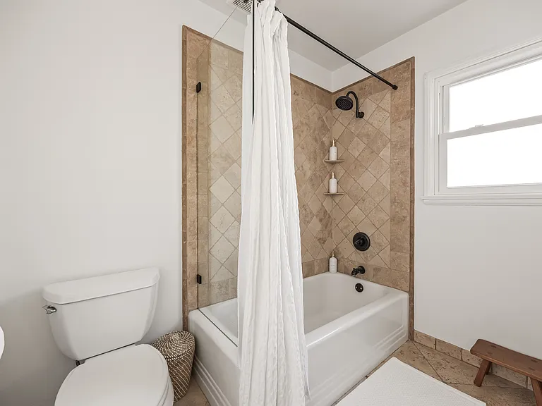 Guest bathroom featuring a tub and shower combination.