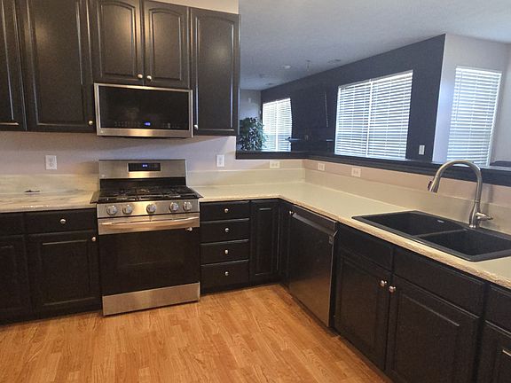 Kitchen: cabinets, stove, microwave, dishwasher, and sink displayed