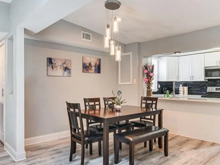 Open dining area with pendant lighting, adjacent breakfast bar, and easy flow into the kitchen for everyday meals.