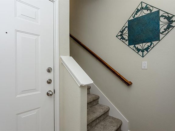 The first floor has a door that leads in from the front porch and a second door that opens to the attached two car garage.
