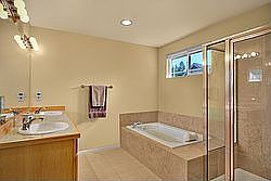 Luxurious master bath with soaking tub and extensive tile work.
