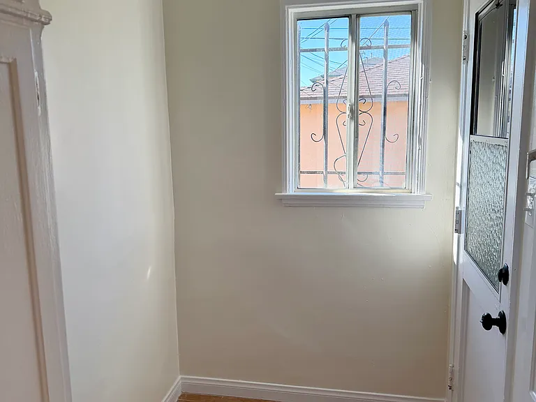 Small room off kitchen with storage and rear exit door.