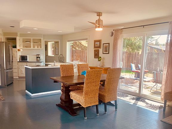 Kitchen and dining room are open and shared with the living room as well. One large open living space. Sliders to the back patio with seating. The table is set up without the extenders, but they are in the closet for more seating.