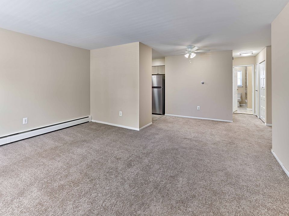Spacious living area with neutral tones and seamless access to kitchen and bath at 42 West Apartments