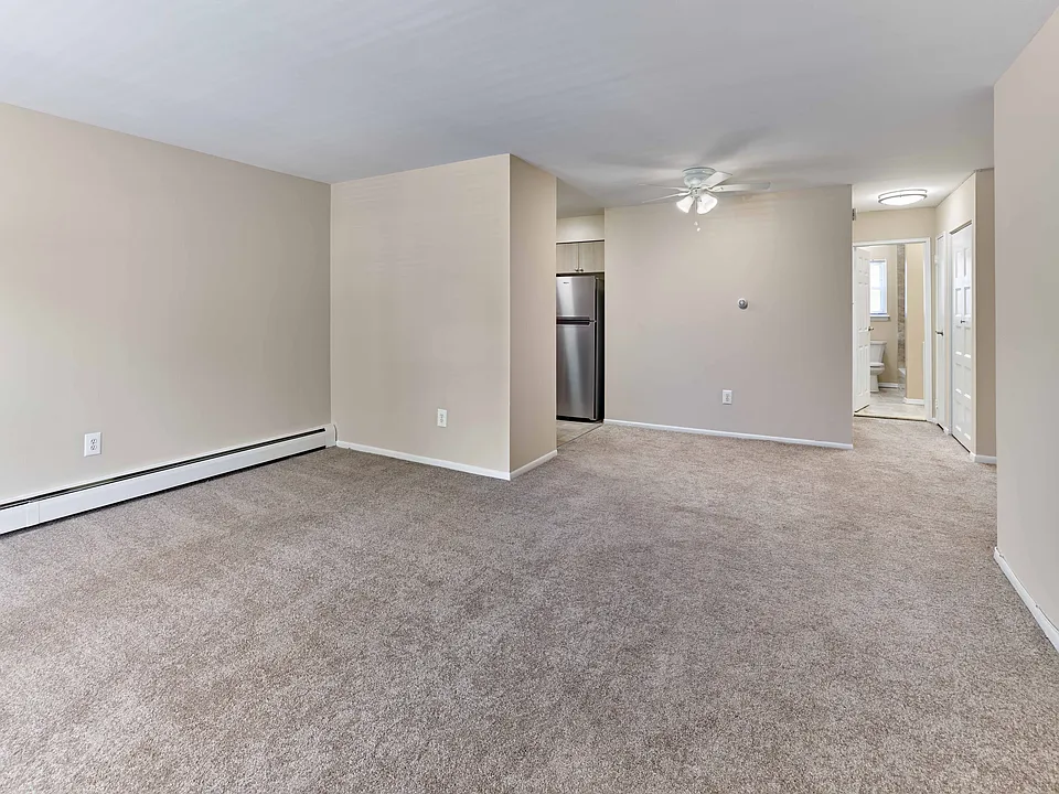 Spacious living area with neutral tones and seamless access to kitchen and bath at 42 West Apartments