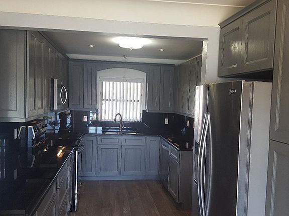 THE KITCHEN HAS BLACK GRANITE COUNTERTOPS AND MATCHING BACKSPLASHS. BRAND NEW APPLIANCES.