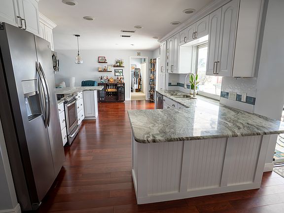 Kitchen, granite countertops, wood flooring, stainless steel fridge and appliances