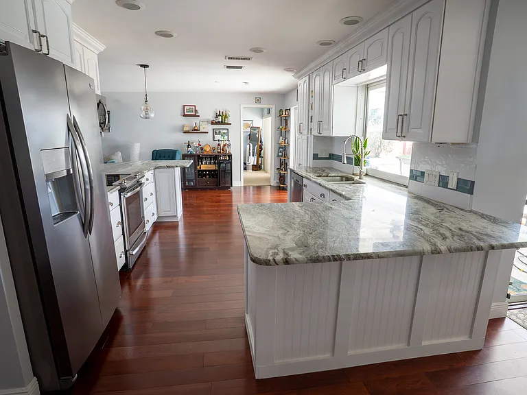 Kitchen, granite countertops, wood flooring, stainless steel fridge and appliances