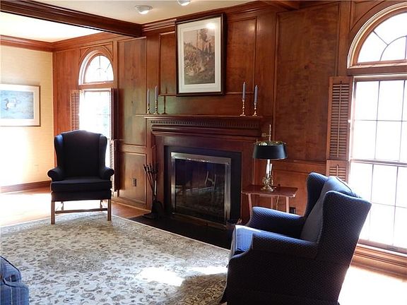 Family Room with beautiful paneling, fireplace, ceiling beams, and sliding door to access deck.