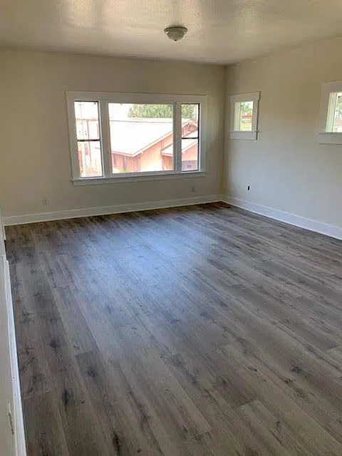 Huge living room with new wood flooring, new windows, and a fresh coat of paint. Lots of natural sunlight.