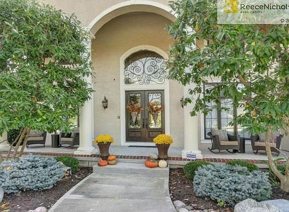 Arched design, lush landscape and double door entry set the stag