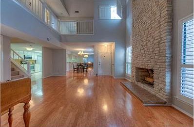 Open living room with soaring ceiling and stone fireplace