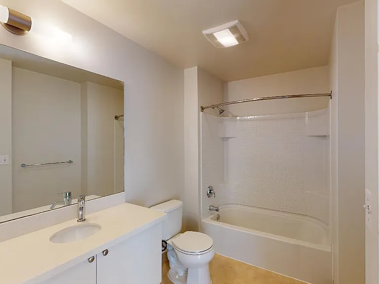 Apartment bathroom with wood-style flooring.
